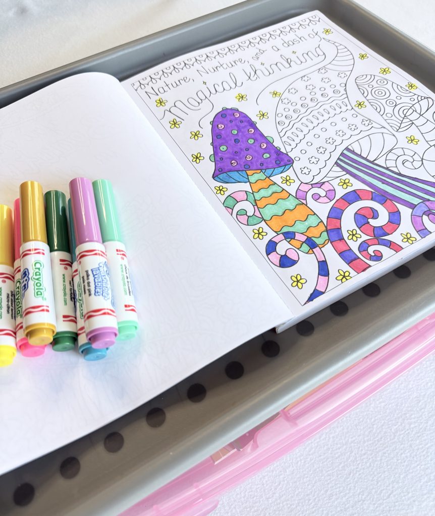 Open colouring book with a stack of colourful markers
