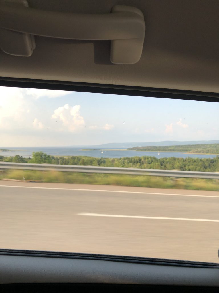 IMG_2423 View from inside a car that is travelling on a highway with ocean in the distance